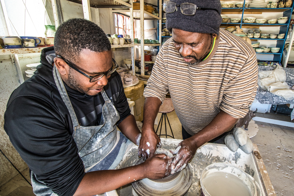 Meshack guiding safari guest Derreck in the art of ceramics