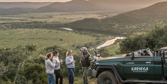Guests enjoying sundowners whilst on game drive_1691751718468