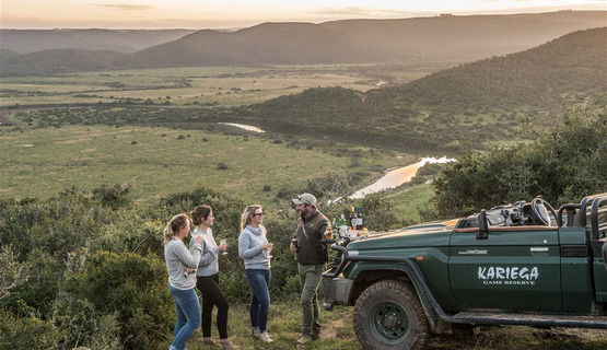 Guests enjoying sundowners whilst on game drive_1691751718468